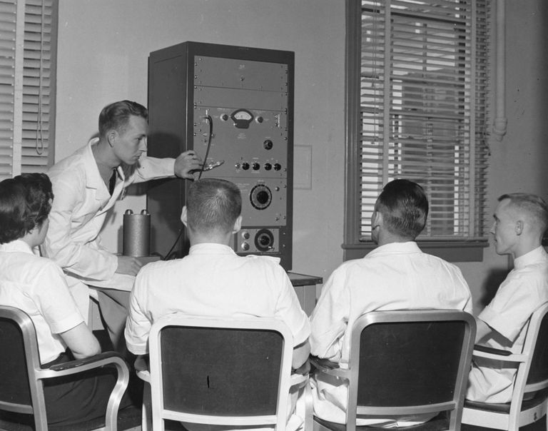 Photo ancienne d'un homme qui intervient devant un groupe. Photo de @navymedicine